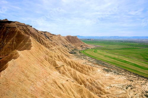 Preview: Stone desert hills near green field
