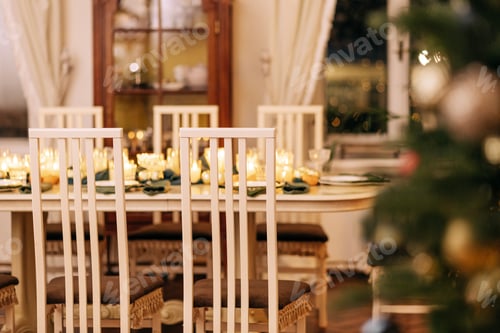 Preview: A dining table covered with candles and Christmas decor. Empty cutlery
