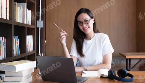 Preview: Smart asian young girl student feel satisfied during internet online courses and smile to you at