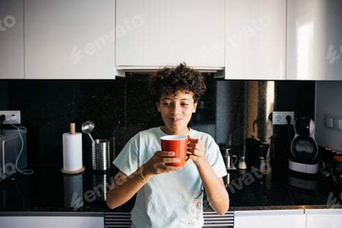 Preview: Teenage Person Holding a Mug in Kitchen