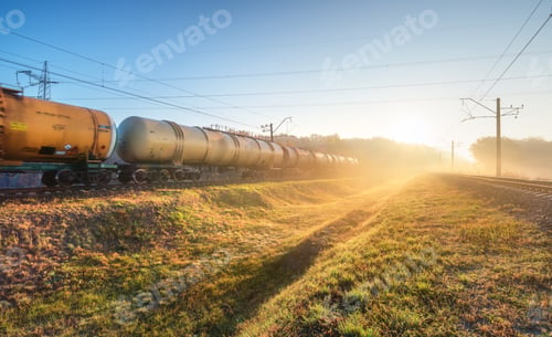 Preview: Moving freight train in fog at sunrise in autumn. Industrial