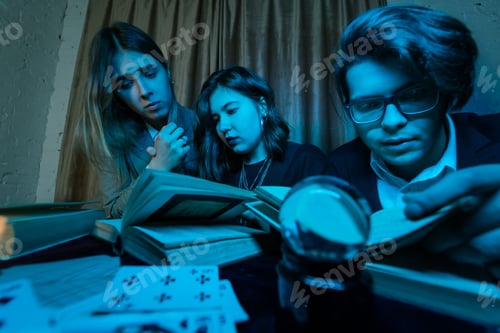 Preview: Two women and a guy are reading a mysterious books, close view
