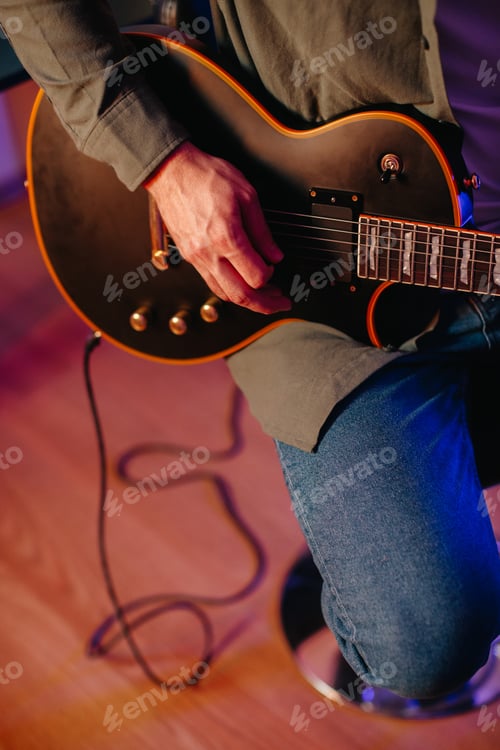 Preview: Musician composing new music playing electric guitar at home
