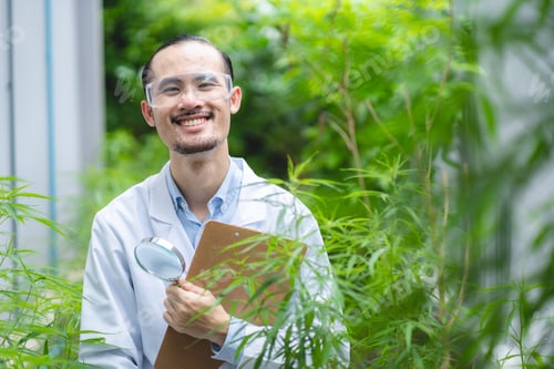 Preview: Smiling Scientist Examining Plants Outdoors with Magnifying Glass