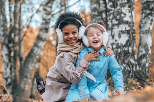 Preview: Two girls having fun at a picnic in the autumn park.Autumn concept.Diverse people.