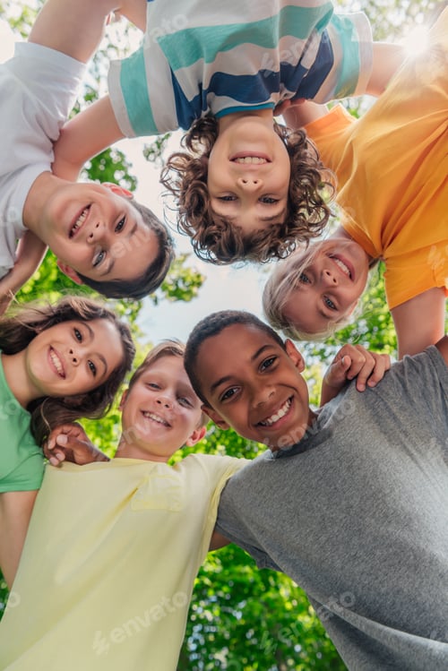 Preview: bottom view of cheerful multicultural children looking at camera in park