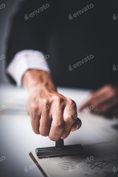 Preview: Close-up Of A Person's Hand Stamping With Approved Stamp On Text Approved