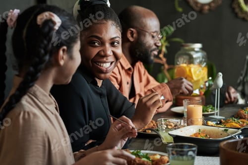 Preview: Happy woman sitting at family dinner