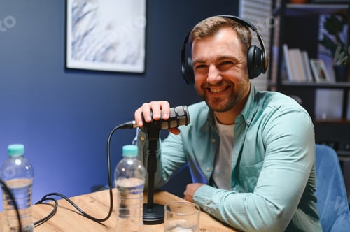 Vista previa: Man podcaster influencer blogger smiling while broadcasting his live audio podcast in studio