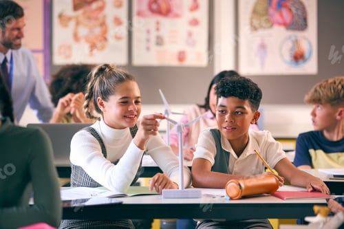 Preview: Secondary Or High School Students Studying Wind Turbines In Science Class With Teacher In Background