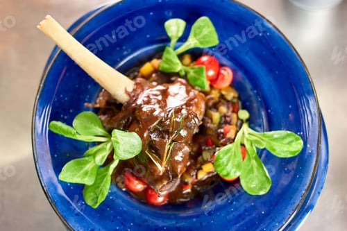 Preview: Cooked lamb shank and side dish, down view.