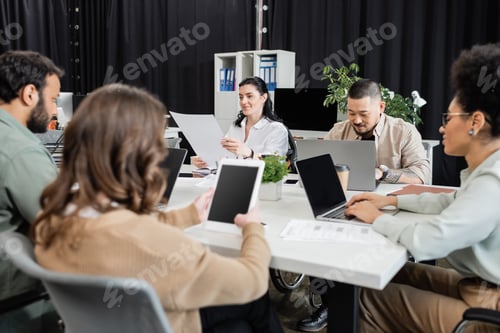 Preview: busy hours in modern coworking, interracial team working on startup project and using devices