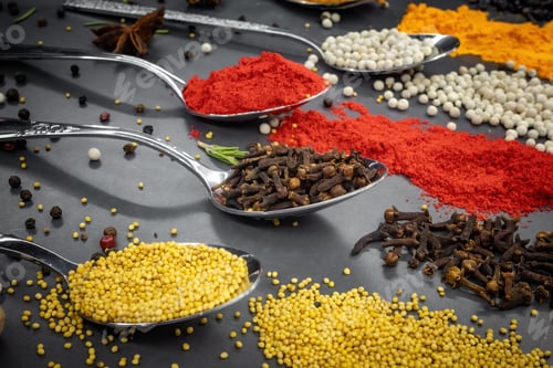 Preview: Collection of spices are spread out on a table. The spices include cumin, paprika, and turmeric