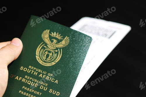 Preview: Closeup shot of a South African passport and a plane ticked with a black background