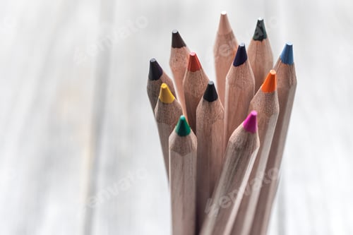 Preview: Close up of colored pencils on a wooden surface.
