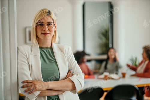 Preview: Confident businesswoman smiling with folded arms in modern office