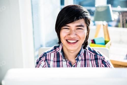 Preview: Smiling hipster businessman looking at camera in office