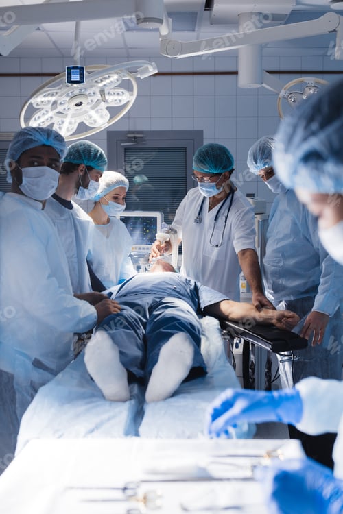 Preview: Surgical tools lying on table with nurse near and surgeons at background.