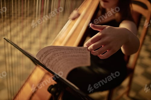 Preview: Hand Woman Turning Page of Music Sheets Reading Notes while Playing Harp in Church