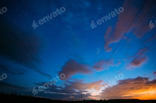 Preview: Night Starry Sky With Glowing Stars Above Countryside Landscape. Light Cloudiness Overcast Above