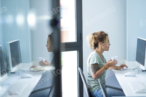 Preview: One cute professional woman entrepreneur working on computer with coffee