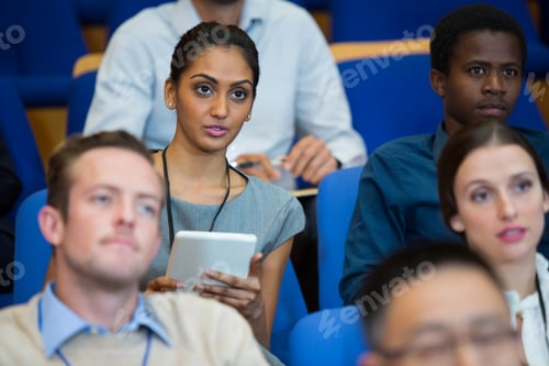 Preview: Business executive participating in a business meeting taking notes