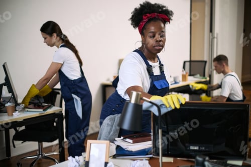 Preview: Young Multiethnic Cleaning Crew Disinfecting Office Workstations during Day