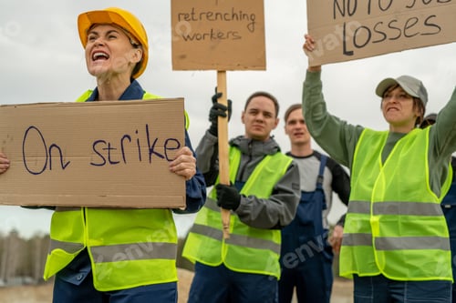 Preview: Group of employees in workwear carrying placards during strike