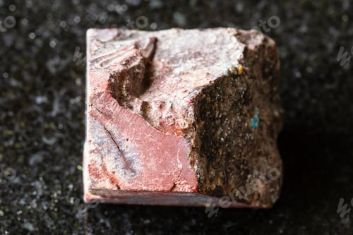 Preview: sample of rough mookaite rock on black granite