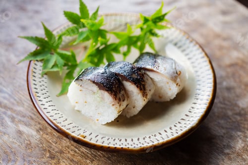 Preview: High angle close up of plate of Sushi and bowl of Soy Sauce on a table in Japanese restaurant.