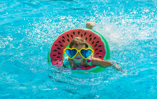 Preview: The child in the pool swims in a circle. Selective focus.