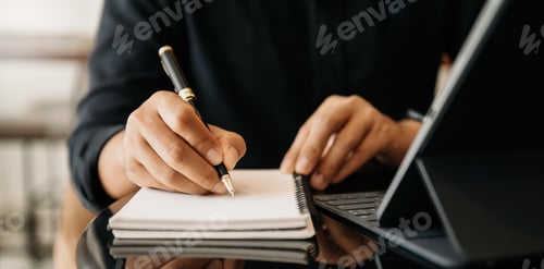 Preview: businessman hand working with new modern computer and writing on the notepad strategy diagram
