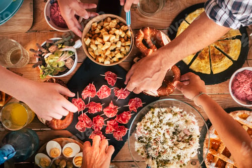 Preview: People enjoying friends concept - Tasty lunch or dinner concept with top view table full of food