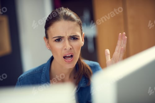 Preview: Shot of a young businesswoman using a computer and looking angry in a modern office