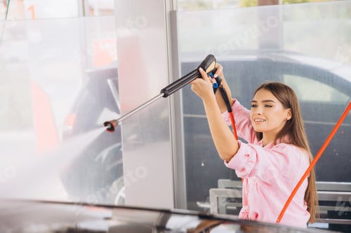 Preview: Young Woman Enjoying a Car Wash with High-Pressure Hose