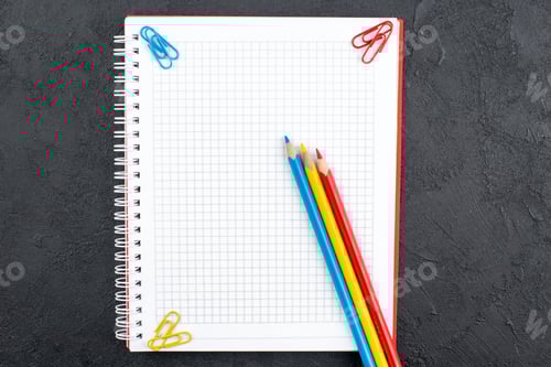 Preview: top view office stuffs notepad red yellow and blue pencils on table