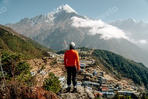 Preview: Scenic Mountainside View, Solitary Hiker on Rocky Outcrop