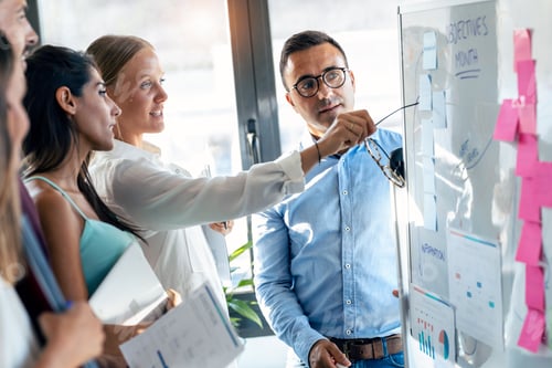 Preview: Elegant mature businessman explaining a project to his colleagues on coworking place.
