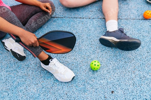 Preview: Multiethnic friends preparing to play pickleball on a blue court