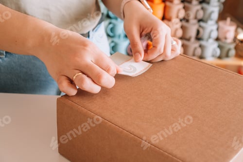Preview: Cropped photo of businesswoman hands packing, preparing parcel for delivery package