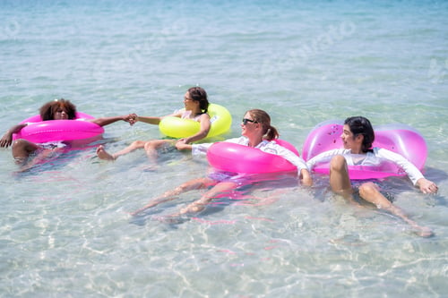 Preview: Teenage girl friendship enjoy laughing play on sea swimming with water inflation toy on blue sky day