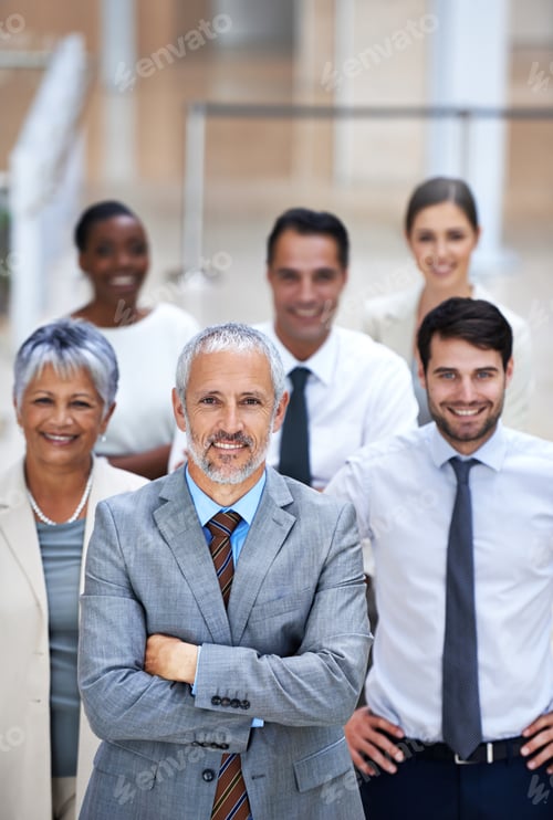 Preview: Portrait of a smiling businessman surrounded by a group of his colleagues