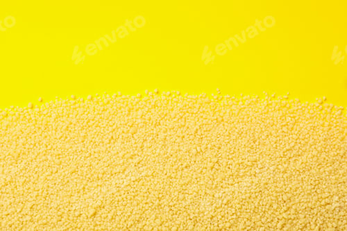 Preview: Raw couscous on yellow background, space for text
