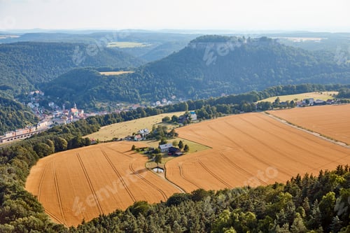 Preview: aerial view of agricultural fields with harvest near village and mountains in Bad Schandau, Germany