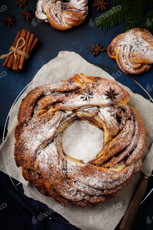 Preview: Christmas pie roll with cinnamon and powdered sugar on a dark old concrete or stone background. Sele