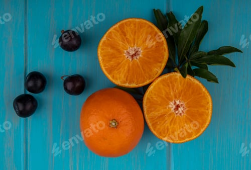 Preview: top view orange slices with cherry plum on a turquoise background