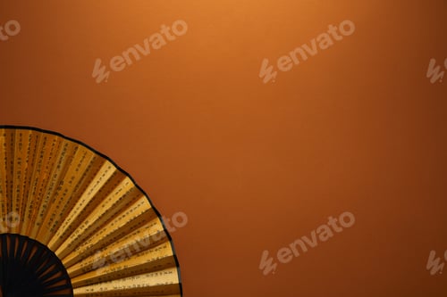 Preview: close-up view of decorative black and golden fan with hieroglyphs on brown background