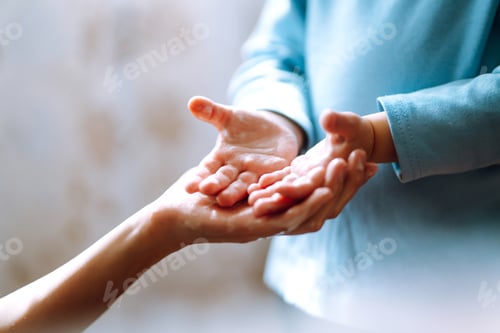 Preview: Mom helps her chaild wash her hands. They are rubbing their hands together creating foam with soap.