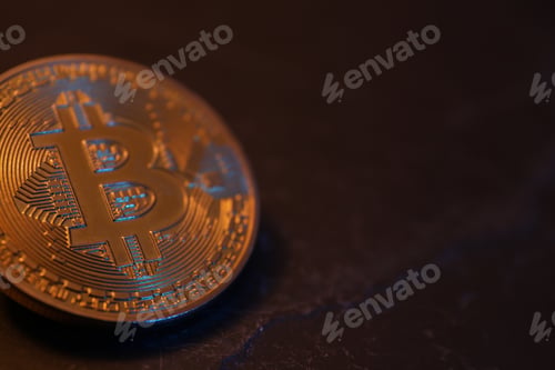 Preview: Cryptocurrency. One golden bitcoin on black table, closeup. Space for text