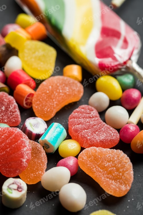 Preview: selective focus of delicious multicolored caramel and jelly sweets on black background